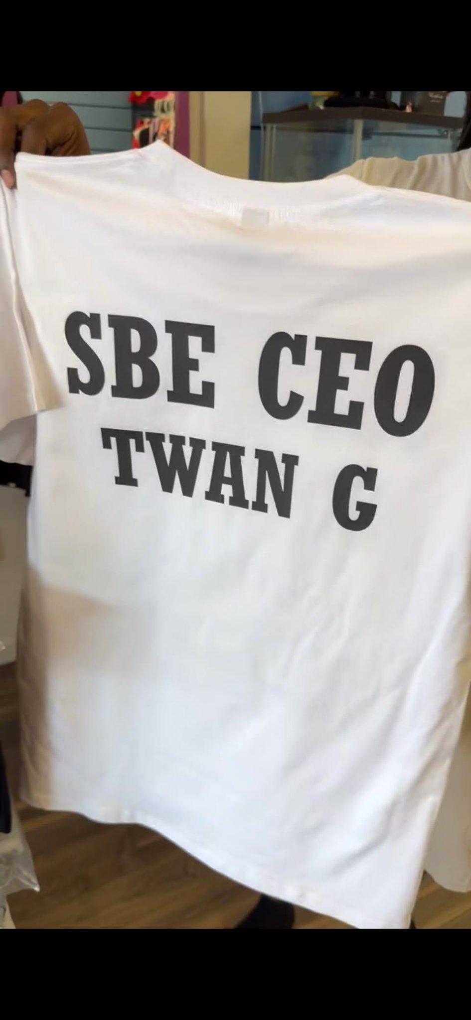Back of a white T-shirt reading SBE CEO Twan G