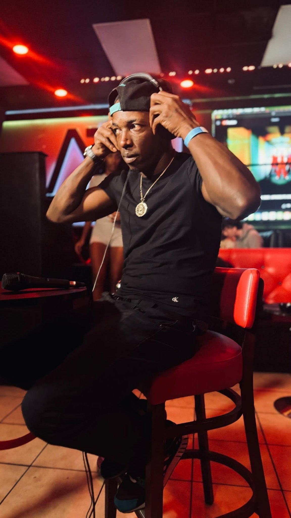 Twan G Young Gutta adjusting headphones while seated at the venue